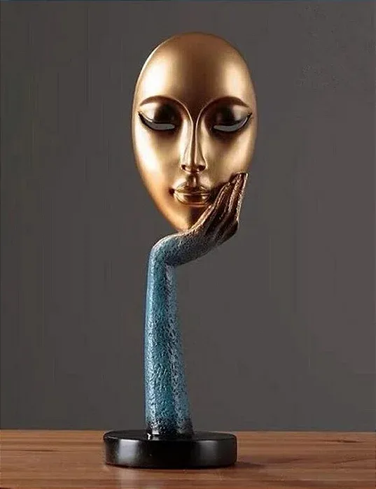 Scultura di un volto in resina dorata appoggiato su una mano e un braccio in resina blu, su base circolare nera